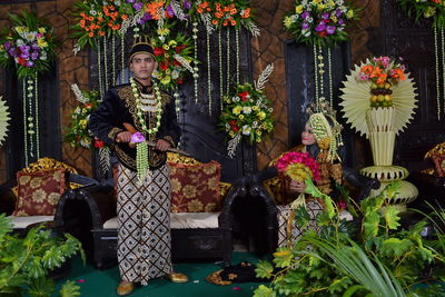 Wedding couple on stage amidst flower decoration