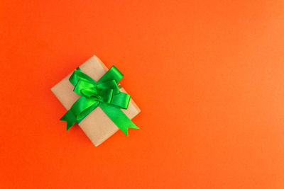 High angle view of multi colored paper against orange background