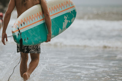 Rear view of surfer on beach