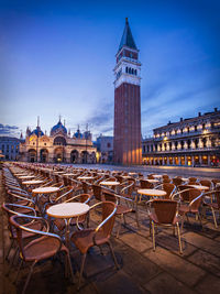 Chairs and table against st marks cathedral at night