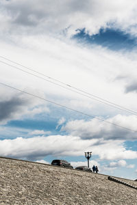 Low angle view of people walking on street against sky