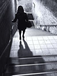 Rear view of woman walking on zebra crossing