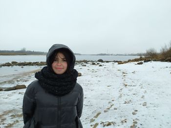 Portrait of young woman standing on snow