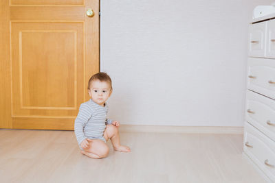 Portrait of cute girl sitting on floor at home