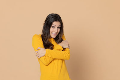 Portrait of a smiling young woman against gray background