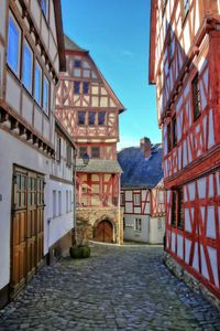 Alley amidst houses and buildings against sky