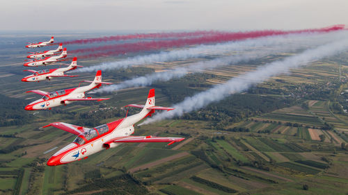 Aerial view of airplane flying over landscape against sky