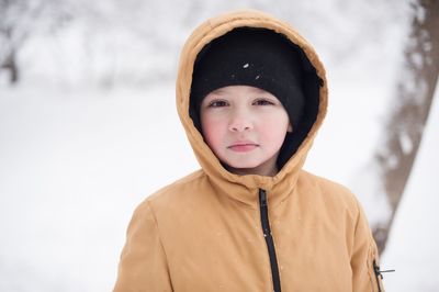 Portrait of young woman standing on snow