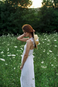 Side view of young woman holding bouquet