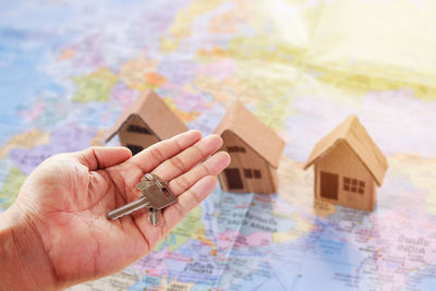 Cropped image of hand holding paper painting