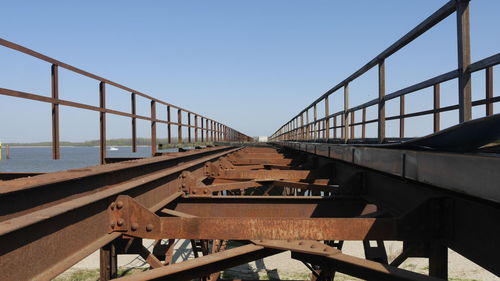 Metal bridge against sky in city