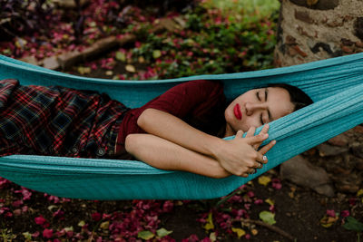 Young woman sleeping on hammock