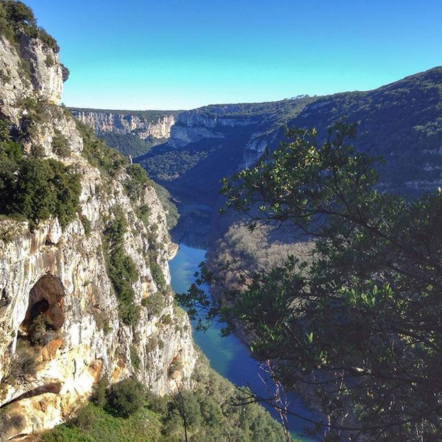 mountain, clear sky, tranquility, tranquil scene, scenics, beauty in nature, blue, water, nature, rock formation, mountain range, idyllic, rock - object, rocky mountains, tree, non-urban scene, landscape, cliff, geology, copy space