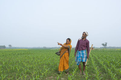 Woman standing on agricultural field against sky
