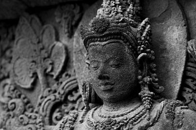 Close-up of buddha statue against old building