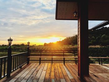 Built structure by railing against sky during sunset