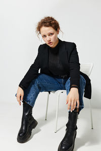 Portrait of girl sitting against white background