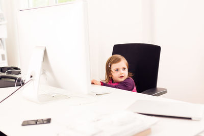 Portrait of girl sitting on table