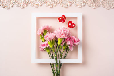Close-up of pink flower vase against white wall