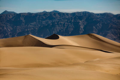 Sand dune in desert against clear sky