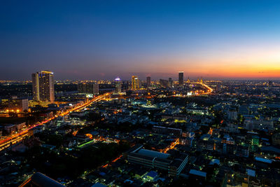 High angle view of illuminated buildings against sky at night