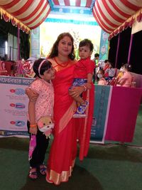 Portrait of happy girl standing against people