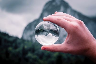 Close-up of hand holding crystal ball