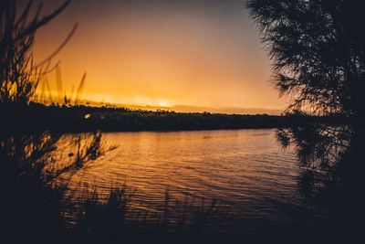 Scenic view of calm lake at sunset