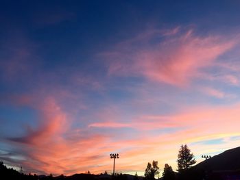 Low angle view of silhouette trees against dramatic sky