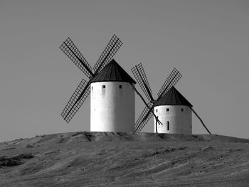 Traditional windmill on landscape against clear sky