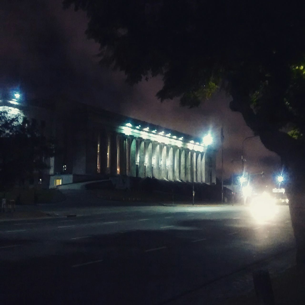 illuminated, night, transportation, street light, road, street, car, built structure, land vehicle, architecture, mode of transport, building exterior, lighting equipment, sky, city, the way forward, road marking, outdoors, tree, light - natural phenomenon