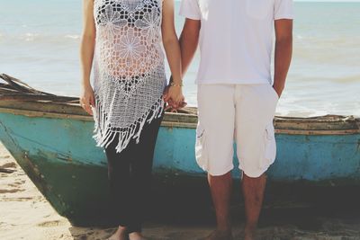 Couple holding hands on beach