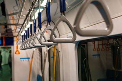 Rows of handrails hang inside a train on the mrt jakarta underground train.