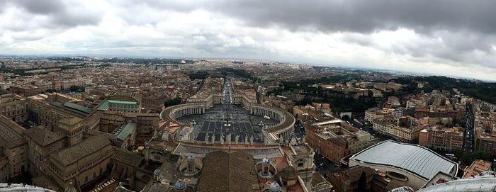 High angle view of city buildings against cloudy sky