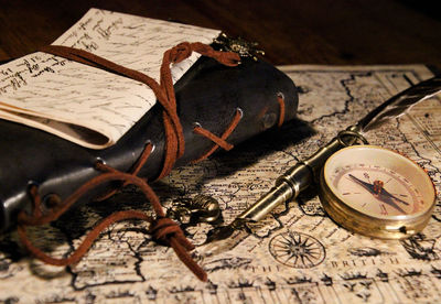 Close-up of book and navigational compass