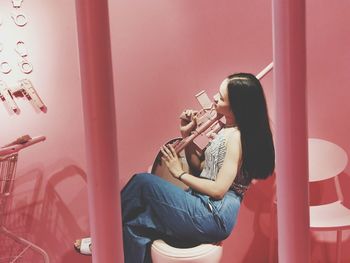 Young woman sitting on wall at home