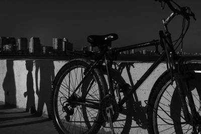 Bicycle parked by wall on sunny day in city