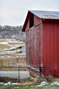 Barn on field against sky during winter