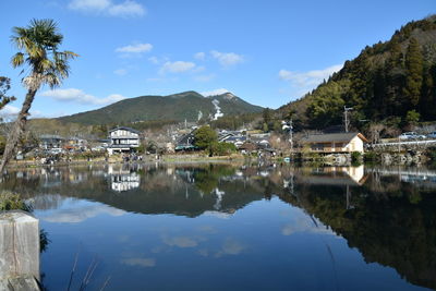 Scenic view of lake by buildings against sky