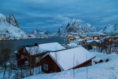 Snow covered houses and buildings against sky