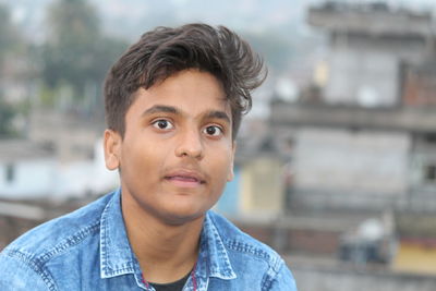 Portrait of young man standing outdoors quite a bit confused. 