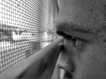 Close-up of man looking through window