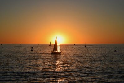 Silhouette of hatch in sea at sunset