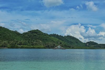 Scenic view of sea and mountains against sky
