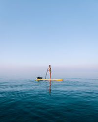 Man surfing in sea against clear sky