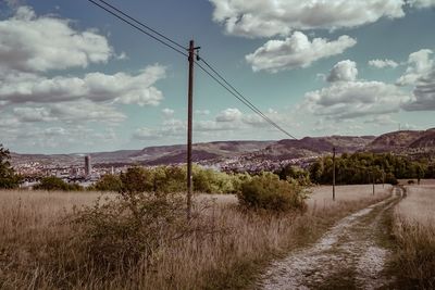 Road amidst field against sky