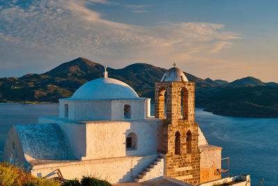 Buildings against sky with mountain range in background