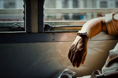 Cropped image of man sitting in train