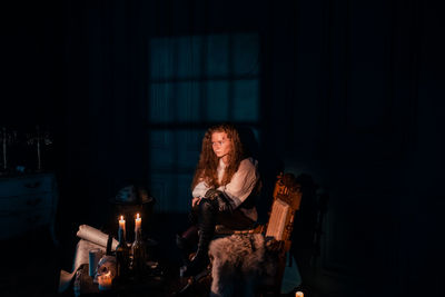 Woman sitting in the dark room