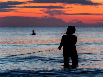 A fisherman is fishing at sunset on koh rong, cambodia